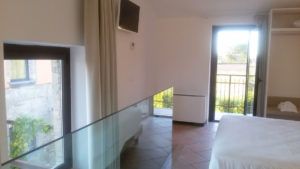 Einfaches Innendesign eines Zimmers mit einem Fenster, das auf einen Balkon blickt.