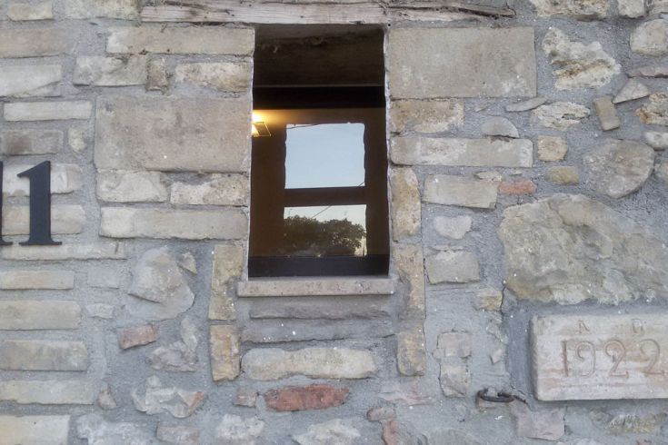 Detail eines Fenster in einer Steinfassade, mit der eingravierten Jahreszahl 1922.