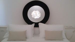 Innenansicht eines Zimmers mit einfacher Dekoration und einer Hängeleuchte.