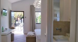 Einfaches und helles Innere mit Blick auf einen gepflegten Garten.