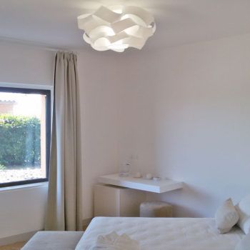 Helles und funktionales Interior eines Schlafzimmers, minimalistisch und schlicht eingerichtet.