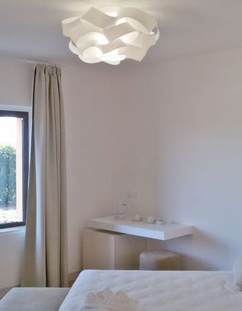 Einfaches und gut beleuchtetes Interieur mit einer eleganten Lampe in einem minimalistischen Raum.