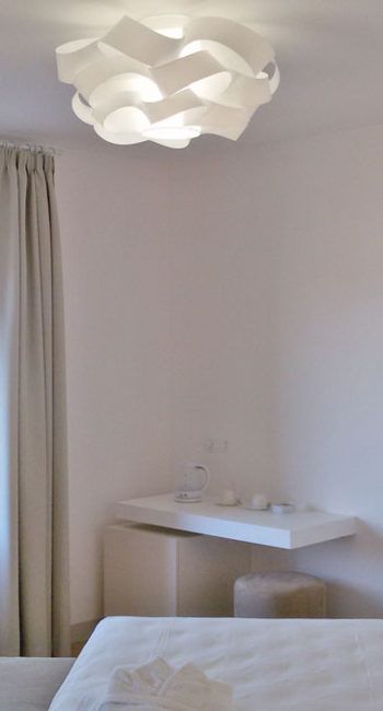 Ein einfacher Raum mit einer modernen Lampe und einer Kaffeeecke.