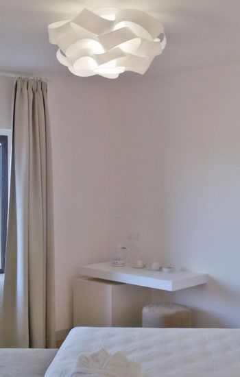 Heller Innenraum mit einem schlichten Kronleuchter und zurückhaltenden Dekorelementen.