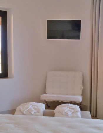 Ecke mit gemütlichen Möbeln und einem wandmontierten Fernseher.