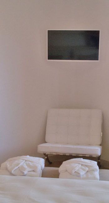 Ein einladender Raum mit einem hellen Sofa und einem Wand-TV, ideal zum Entspannen.