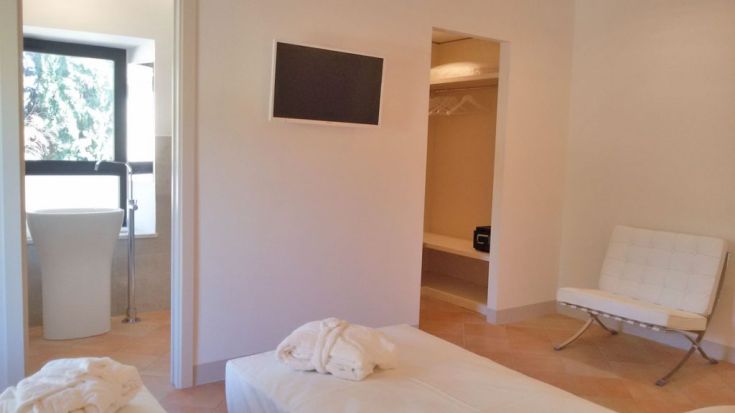 Ein einfaches und funktionales Zimmer mit Betten, Schränken und einem modernen Badezimmer.