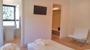 Ein geräumiges zeitgenössisches Zimmer mit Betten und einem Fernseher, gut beleuchtet und modern eingerichtet.