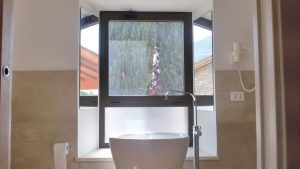 Ein modernes Badezimmer mit einem Fenster, das auf eine Naturszene blickt.