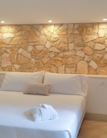 Ein gemütliches Schlafzimmer mit hellen Steinwänden und einfacher Einrichtung.