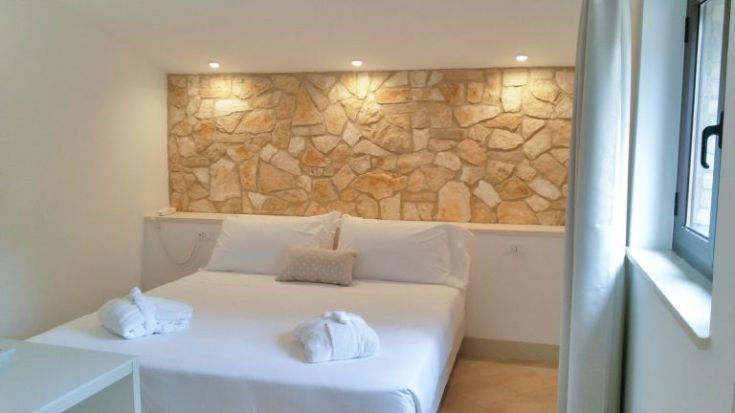 Moderne und gemütliche Zimmer mit einer Steinstützwand und gut eingerichtet.