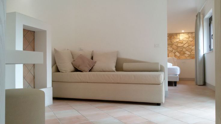 Ein geräumiges und helles Wohnzimmer mit einem ansprechenden Sofa und passenden Accessoires.