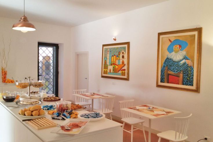 Ein einfacher Frühstücksraum mit weißen Tischen, informell dekoriert.