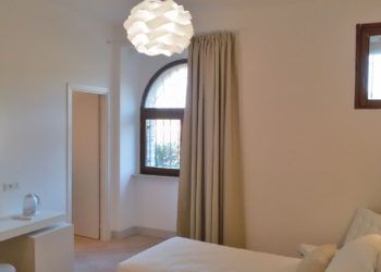 Ein geräumiges und gut beleuchtetes Zimmer mit zeitgenössischen und funktionalen Möbeln.