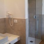 Moderner Badezimmer mit Dusche und warmen, einladenden Möbeln.