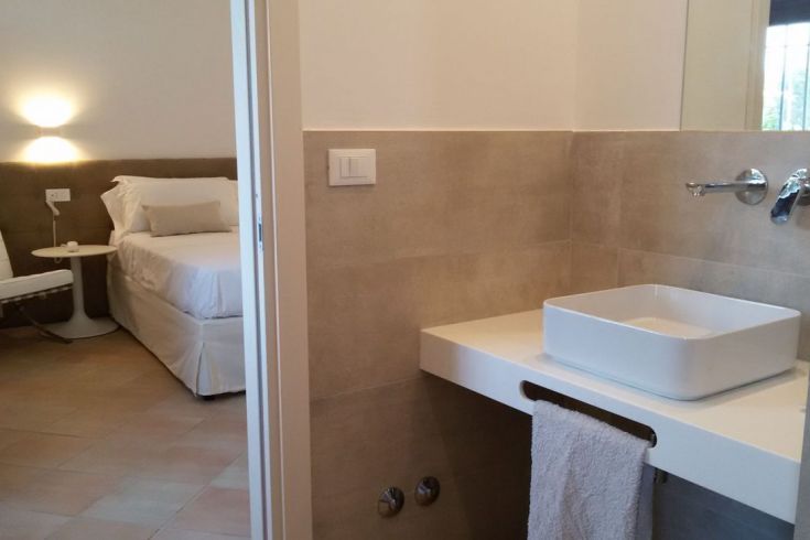 Ein gemütliches Zimmer mit einem Bett und einem angrenzenden Badezimmer, das eine entspannende Atmosphäre bietet.