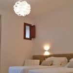 Einzelzimmer mit funktionaler Lampe, die warmes Licht spendet.