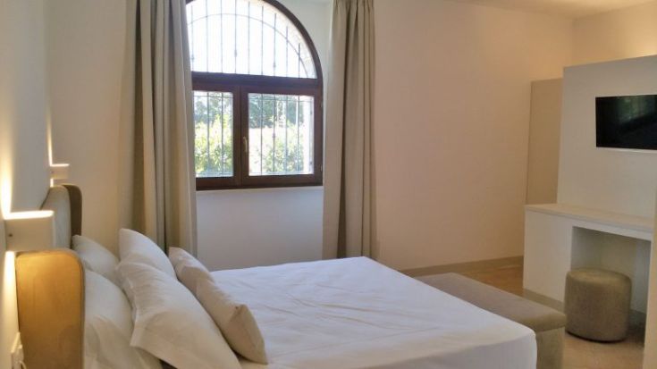 Gemütliches Zimmer mit einem Doppelbett und einem großen Fenster, das den Raum erhellt.