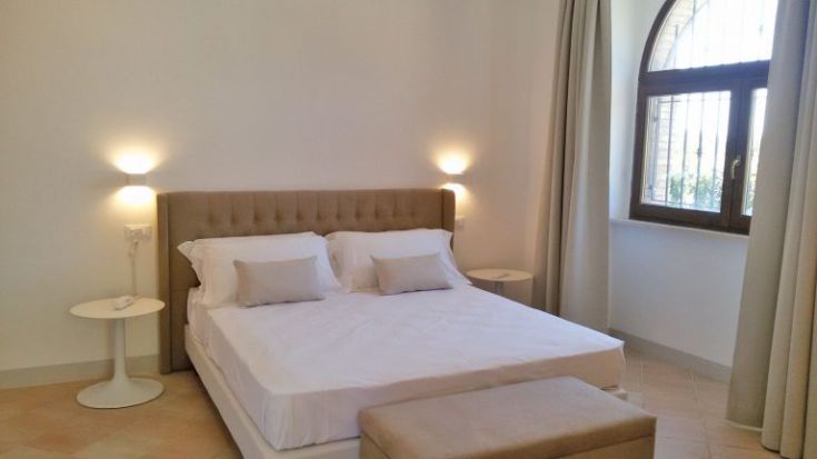 Geräumiges und helles Schlafzimmer mit einem Doppelbett und zeitgenössischen Möbeln.