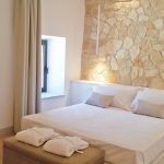 Ein einfaches und gemütliches Zimmer mit Steinwänden und bequemen Betten.