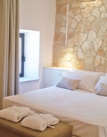 Ein Schlafzimmer mit Steinwänden und schlichten Möbeln.