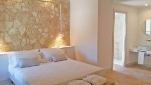 Gemütliches Zimmer mit Steinwand und eigenem Bad in einer rustikalen und ruhigen Umgebung.