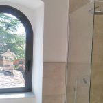 Ein gepflegtes Badezimmer mit einem großen Bogenfenster, das den Raum erhellt.