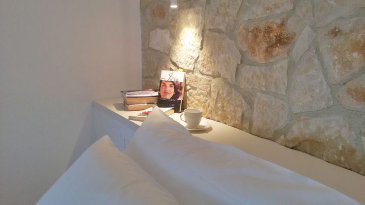 Ein intimer Raum mit Steinwänden, eingerichtet mit Büchern und einer Tasse Kaffee.