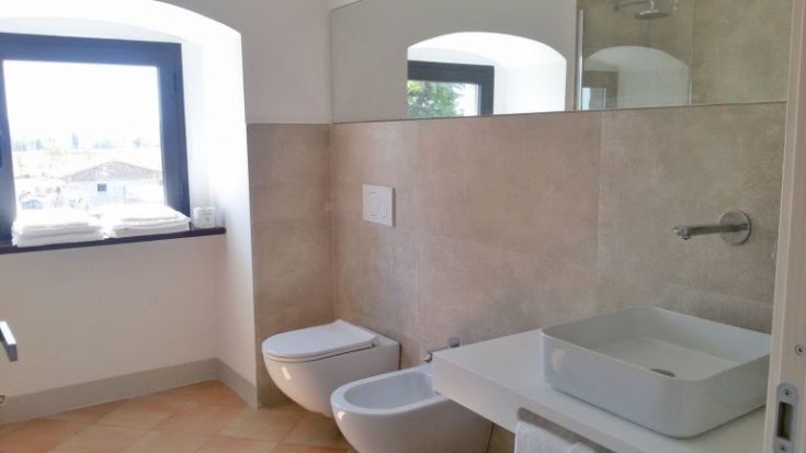 Ein modernes Badezimmer mit einem einfachen und funktionalen Design, das über ein Fenster verfügt, das den Raum erhellt.