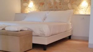 Ein einfaches und einladendes Schlafzimmer, sanft beleuchtet und mit linearen Möbeln eingerichtet.