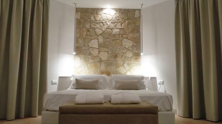 Gemütliches Zimmer mit Steinwand und sanfter Beleuchtung, einfach und einladend.