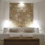 Einfaches Zimmer mit Steinwand und Doppelbetten.