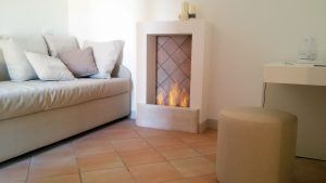 Gemütliches Interieur mit Sofa und brennendem Kamin, das Wärme in die Atmosphäre bringt.