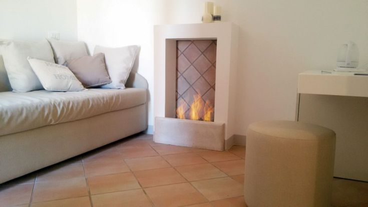 Ein gemütlicher Wohnbereich mit Sofa, Kamin und sanfter Beleuchtung.