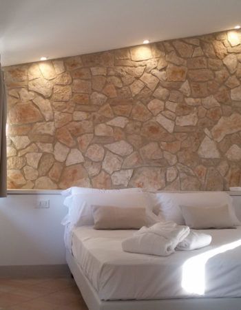 Zimmerinterieur mit einer Steinwand und sanfter Beleuchtung.