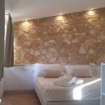 Gemütliches Zimmer mit einer Steinwand und warmem Licht, das eine einladende Atmosphäre schafft.