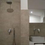 Ein modernes Badezimmer mit Dusche und Waschbecken, gekennzeichnet durch helle Farben.