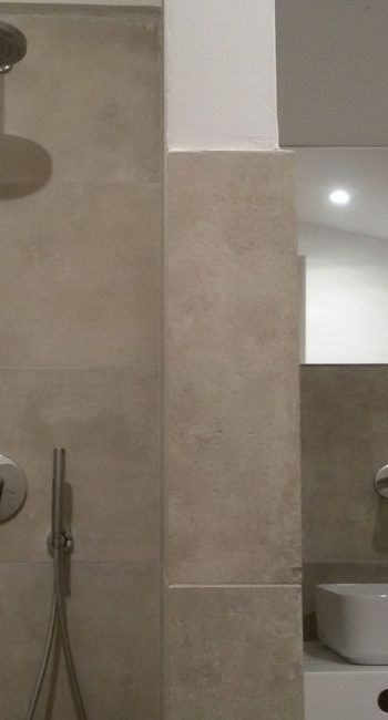 Zeitgemäßes Badezimmer mit hellen Fliesenwänden und modernen Möbeln in einem minimalistischen Ambiente.