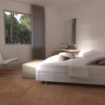 Ein einladendes, helles Schlafzimmer mit schlichten Möbeln und Blick ins Grüne.