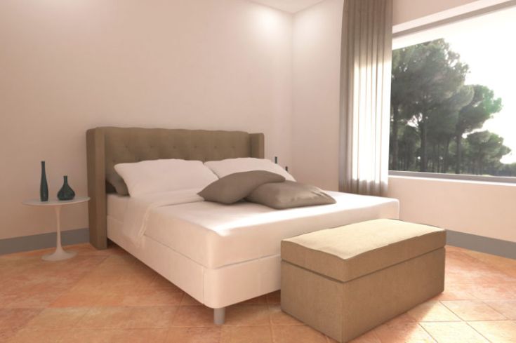 Ein helles Schlafzimmer mit einem Doppelbett und großen Fenstern, die auf Bäume blicken.