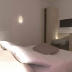 Innenansicht eines einfachen und gemütlichen Schlafzimmers mit funktionalem Mobiliar und einer ruhigen Atmosphäre.