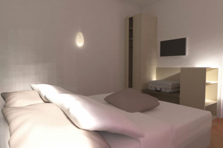 Ein einfaches und gut beleuchtetes Schlafzimmer mit einem Doppelbett und einem Fernseher.