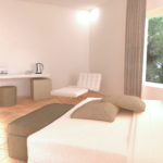 Gemütliches und gut beleuchtetes Zimmer mit bequemen Betten und gepflegten Oberflächen.