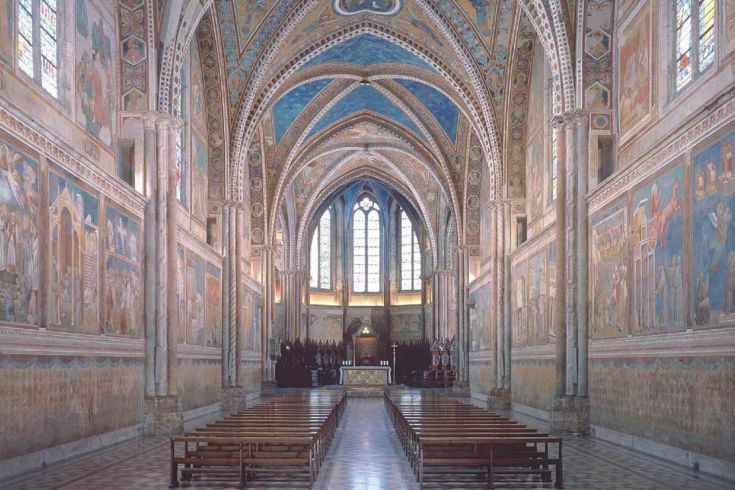 Inneres einer Kirche mit Fresken und gotischen Architekturelementen.