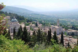 Ein Panorama einer historischen Stadt mit grünen Hügeln im Hintergrund.