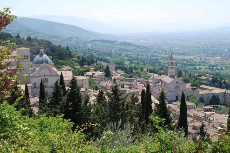 Szene einer friedlichen Stadt, umgeben von sanften grünen Hügeln.
