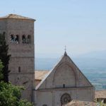 Panorama der historischen Kirche mit ihrem Turm und den umliegenden Hügeln.