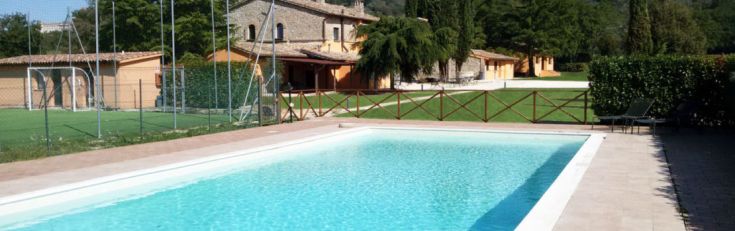 Ein Pool, eingebettet in die Natur, umgeben von typischer Vegetation einer ländlichen Gegend.