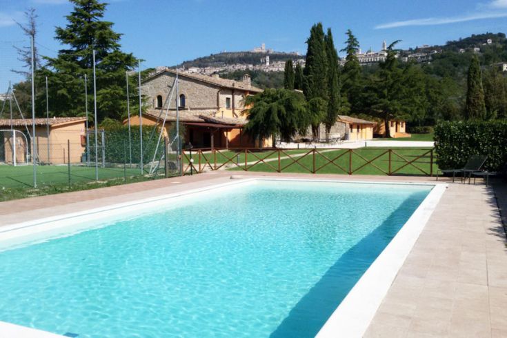 Ein sauberer Swimmingpool, umgeben von üppigem Grün, mit Steinkanten.
