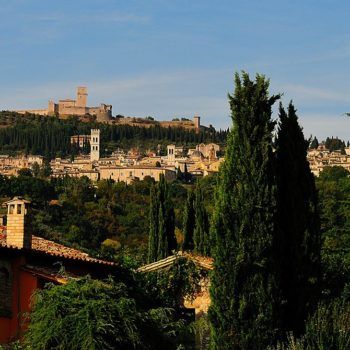 Eine malerische Hügellandschaft mit einem historischen Gebäude und einem kleinen Dorf.
